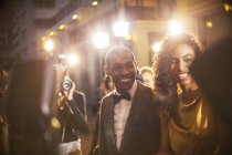 Casal de celebridades sorrindo sendo fotografado por paparazzi no evento — Fotografia de Stock