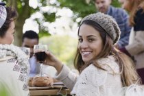 Ritratto donna sorridente bere vino a pranzo patio con gli amici — Foto stock