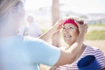 Instructor de yoga ajustando diadema de mujer mayor - foto de stock