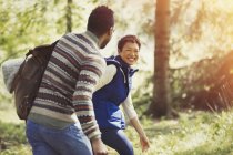 Lachendes Paar wandert mit Rucksack im Wald — Stockfoto