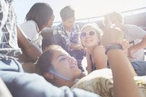 Teenage friends hanging out texting on sunny day — Stock Photo