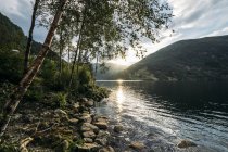 Солнце садится над спокойным озером, Норвегия — стоковое фото