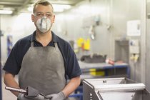 Ritratto fiducioso lavoratore indossando maschera protettiva in fabbrica di acciaio — Foto stock