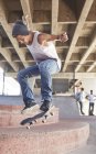 Adolescente saltando monopatín en el parque de skate - foto de stock