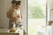 Liebevolles schwangeres Paar bereitet Schaumbad vor — Stockfoto