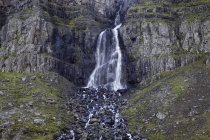 Водопад и скалистая скала в дневное время — стоковое фото