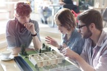Architects brainstorming at building model in office — Stock Photo