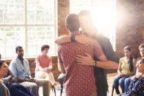Men hugging at group therapy session — Stock Photo