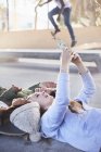 Teenage girls laying taking selfie with camera phone at skate park — Stock Photo