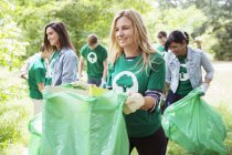 Volontario ambientalista sorridente che raccoglie spazzatura — Foto stock