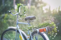 Цветы и гирлянды на велосипеде в саду — стоковое фото