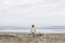 Mädchen rennt am Strand auf Ozean zu — Stockfoto