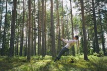 Runner utilizzando banda di resistenza su albero nei boschi — Foto stock