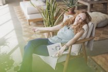 Femme sereine avec sieste livre dans un fauteuil — Photo de stock