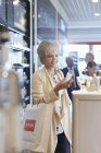 Femme faisant des emplettes de parfum dans la boutique hors taxes de l'aéroport — Photo de stock