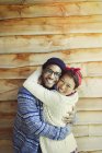 Portrait enthusiastic couple hugging and smiling outside cabin — Stock Photo
