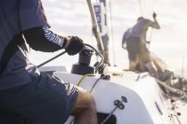 Uomo in possesso di vela sartiame su barca a vela — Foto stock