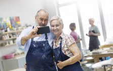 Casal sênior tirando selfie no estúdio de cerâmica — Fotografia de Stock