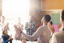Audience clapping for man with arms outstretched in community center — Stock Photo