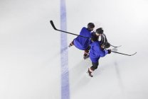 Jugadores de hockey bloqueando oponente en hielo - foto de stock