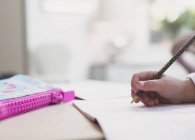 Крупним планом дівчина робить домашнє завдання з олівцем — стокове фото