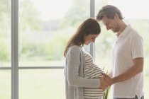 Ласковая беременная пара трогает живот — стоковое фото