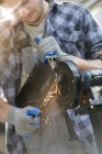Trabajador metalúrgico usando lijadora en taller - foto de stock