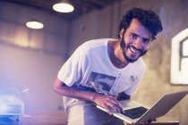Empresário casual entusiasta de retrato com laptop no escritório — Fotografia de Stock