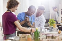 Chef insegnante e studenti utilizzando miscelatore mano in cucina classe — Foto stock