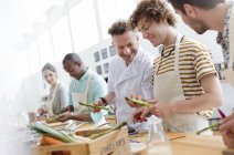 Chef teacher and students in cooking class kitchen — Stock Photo