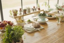 Хліб, масло, фрукти, макаронні вироби, аспарагус і свіжі трави на обідньому столі — стокове фото