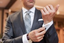 Close up well-dressed businessman adjusting cufflinks — Stock Photo
