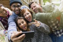 Playful friends with camera phone gesturing taking selfie — Stock Photo