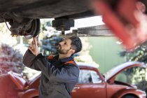Mechaniker unter Auto befestigt Bremsen — Stockfoto