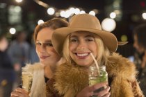 Portrait smiling young women drinking cocktails at party — Stock Photo