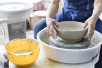 Senior man using pottery wheel in studio — Stock Photo