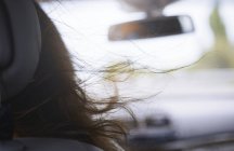Mujer cabello soplando en coche - foto de stock
