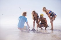 Чоловік викладає друзям кіоск на сонячному пляжі — стокове фото