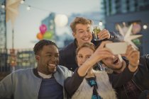 Giovani amici adulti che scattano selfie alla festa sul tetto — Foto stock