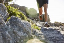 Male runner running on rocky trail — Stock Photo