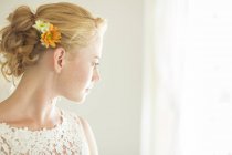 Portrait of young bride looking out of window — Stock Photo