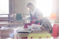 Kreative Geschäftsfrauen begutachten Dokumenteneditionen im sonnigen Büro — Stockfoto