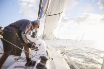 Caucasian retired man sailing on sunny ocean — Stock Photo