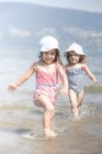 Las niñas vadeando en el océano - foto de stock