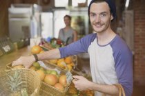 Retrato sonriente hombre de compras de naranjas en el mercado - foto de stock