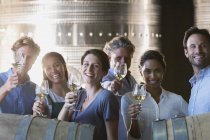 Portrait smiling friends wine tasting in winery cellar — Stock Photo