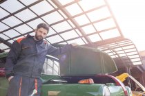 Portrait confiant mécanicien fixation voiture classique dans l'atelier de réparation automobile — Photo de stock