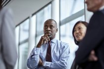 Attentive serious businessman listening to colleagues — Stock Photo