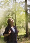 Donna serena crogiolarsi alla luce del sole escursioni nei boschi — Foto stock