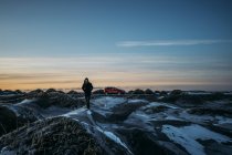 Mann läuft auf vereisten Hügeln in abgelegener Landschaft, Hof, Island — Stockfoto